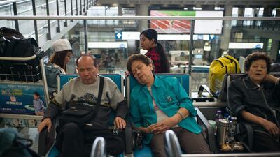 Passengers rest as they wait to find out the status of their flights after Typhoon Nida caused chaos at the international airport in Hong Kong. Hordes of angry passengers stranded after Typhoon Nida pummelled Hong Kong crowded the airport on Tuesday, desperately seeking flights as the city emerges from lockdown while the storm swept across southern China. Anthony Wallace / AFP