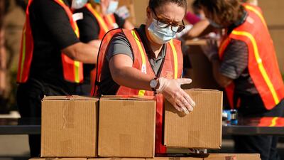 Kristen McKenna, center, and other volunteers pack boxes of food outside Second Harvest Food Bank in Irvine, California. AP Photo