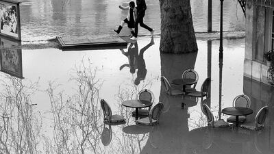 Pedestrians walk along the Seine river in the Chatou suburb of Paris, France in this black and white image. Water levels continue to rise after weeks of heavy rain in France. Pascal Le Segretain / Getty Images