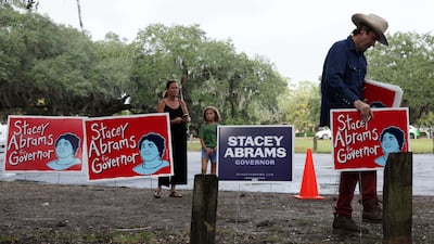 A supporter lays out campaign signs he created for Ms Abrams before a rally on November 5 in Savannah. Getty / AFP