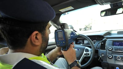 A policeman holding a speed gun. Courtesy: Abu Dhabi police.