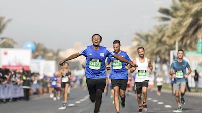 Runners arriving at the finish line at the Standard Chartered Dubai Marathon. The National