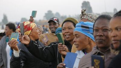 South Africans show their ID cards as they stand in line at a polling station. About 25 million people were eligible to vote in the elections. Kim Ludbrook / EPA