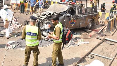 Officials examine the site of the bomb blast. EPA