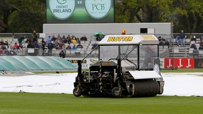 Groundsmen work on the wet pitch at Malahide as the start of play is delayed on the first day of the Test. Paul Faith / AFP