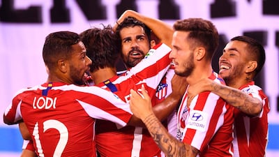 Costa, centre, is mobbed by his Atletico Madrid teammates. AFP