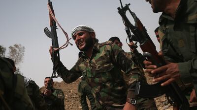 Volunteers from the Badr Brigade cheer after an exchange of fire with ISIS fighters on the front line in Ebrahim Ben Ali, Iraq in 2015. Getty Images