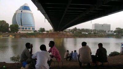 Sudanese drink tea by the Nile under a bridge leading to the Burj Al-Fateh hotel. AFP