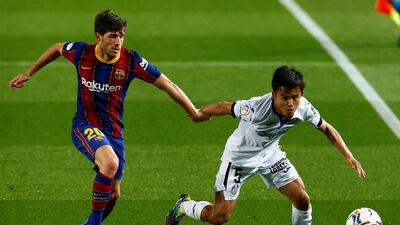Getafe's midfielder Takefusa Kubo against Sergi Roberto at Camp Nou. EPA