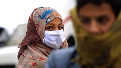 A woman wearing a protective face mask walks in a street in the capital Sanaa amid concerns over the spread of the novel coronavirus in Yemen. AFP
