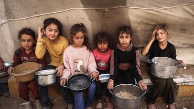 Palestinian children collect aid food at Bureij refugee camp in the central Gaza city. AFP