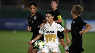 Players in action during the U14 Mina Cup final match between Pumas (white) and City Football Club.