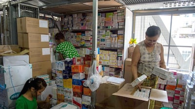 The Myanmar pharmacy shop owner Aye Aye Nge nspects items from her stall in a new commercial building at the Shwe Mingalar market in Yangon. It was only when her pharmacy burned down for the second time that she thought about taking out insurance. Romeo Gacad / AFP