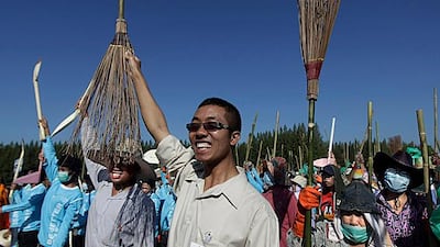 City workers, volunteers raise their brooms and spades as they shout slogans before starting a cleaning operation in Patum Thani on the outskirts of Bangkok. Altaf Qadri / AP Photo