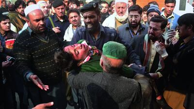 Hospital security guards carry students injured in the shootout at a school under attacked by Taliban gunmen in Peshawar on December 16. Taliban gunmen stormed a military school in the northwestern Pakistani city, killing and wounding dozens, officials said, in the latest militant violence to hit the already troubled region. Mohammad Sajjad / AP Photo