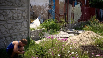 A boy picks flowers in the ruins of Simonovka. Photo: Lalage Snow