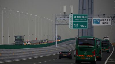 Policemen stand near a double-decker bus stopped on the other side of the road.