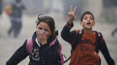 Palestinian children run to take cover during clashes. Mahmoud Abbas warned earlier this week that the region could plunge into a "religious war" over the Israeli plan.