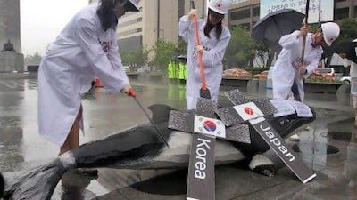 Activists pretend to carve up a model of a whale in Seoul in protest against the government's plans to resume whaling.