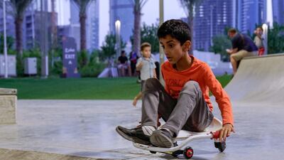 A boy slides down a ramp at the skate park in Reem Central Park.
