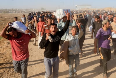 Palestinians carry aid supplies from the US -backed Gaza Humanitarian Foundation, in Khan Younis, in the southern Gaza Strip, May 29, 2025. REUTERS
