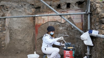 A restorer performs deep consolidation of an unearthed wall.