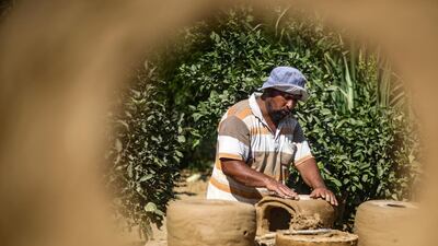 Palestinian Mohammad al-Najjar, 40, sculpts cooking stoves from clay and wheat straw in the garden of his house in Khan Yunis in the southern Gaza Strip. AFP