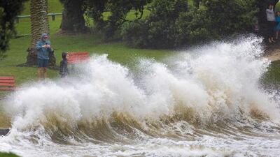 Waves crash against a sea wall at an Auckland beach as a cyclone hits the upper parts of New Zealand. AP