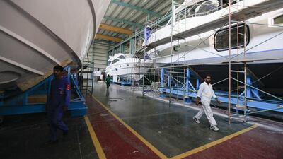 Workers in the production warehouse at the Gulf Craft factory in Umm Al Quwain. Sarah Dea / The National