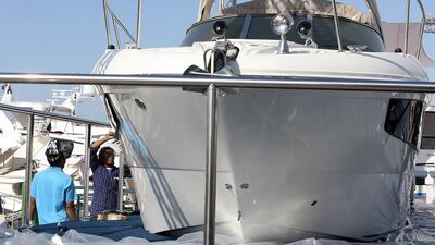Crew members ready a boat for display for the Dubai International Boat Show. Pawan Singh / The National