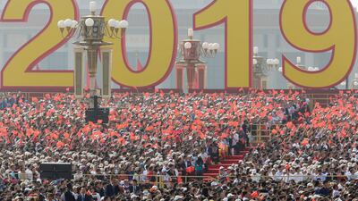 People wave Chinese flags before the military parade. Reuters