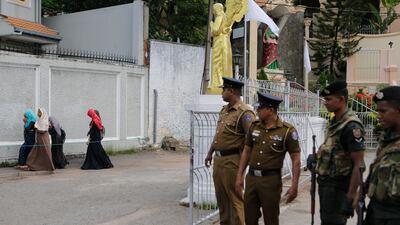 In this Sunday, May 12, 2019, photo, Sri Lankan soldiers watch as a group of Muslim students walk past a closed catholic convent in Colombo, Sri Lanka. AP