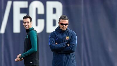Barcelona’s Sergio Busquets smiles past Barcelona manager Luis Enrique during training. Lluis Gene / AFP
