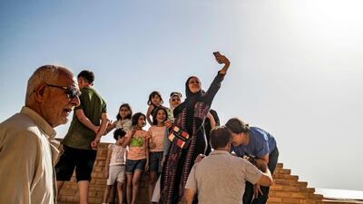 People visit the ruins of the Jaabar Citadel (Qalaat Jaabar) in Syria's Lake Assad reservoir in Raqa province on June 3, 2022. - The ancient lake-side fortress, once used by jihadists to launch attacks, is slowly regaining its status as a top cultural destination, attracting visitors from across war-torn Syria. Families posed for pictures under the hot June sun, some perched on an ancient brick wall overlooking the banks of Lake Assad, a man-made reservoir in north Syria's Raqa province. (Photo by Delil SOULEIMAN / AFP)