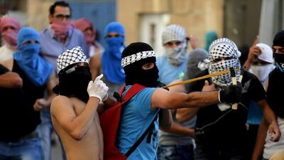 A Palestinian protester uses a slingshot to hurl a stone towards Israeli police during clashes in Shuafat, an Arab suburb of Jerusalem. Ammar Awad / Reuters