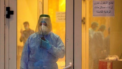 A medical staffer wearing full PPE (personal protective equipment) stands with a radio transceiver at the entrance of an isolated section for Covid-19 treatment at a hotel in the sports city of Iraq's southern city of Basra. AFP