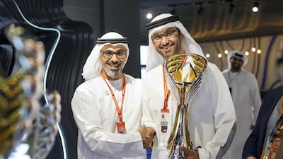 Sheikh Khalid bin Mohamed bin Zayed and Dr Sultan Al Jaber, Minister of State and chief executive of Adnoc, show off the new Formula One trophy