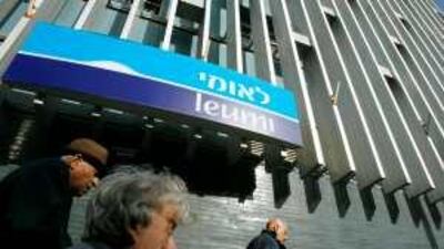 People walk past a Tel Aviv branch of Bank Leumi, which is accused of withholding deposits from families of victims of the Holocaust.