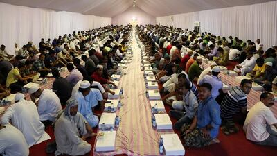 People wait with food boxes on the first day of Ramadan at the Sheikh Zayed Grand Mosque in Abu Dhabi. Pawan Singh / The National
