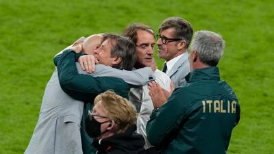 Italy's coach Roberto Mancini and staff members celebrate after winning the Euro 2020 semi-final against Spain at Wembley Stadium in London.