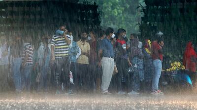 Commuters in Jammu take shelter in heavy rain.