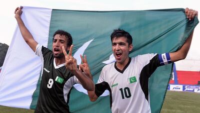 Pakistani football team captain Kaleem Ullah, right, with teammate Saddam Hussain, who both scored goals in the match, celebrate their two-goal victory against India in their second friendly football match at Bangalore at the Karnataka State Football Association Stadium in Bangalore on August 20, 2014. Pakistan pulled off a surprise 2-0 win over India. Manjunath KIRAN / AFP