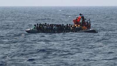 The SOS Mediterranee rescue team distributes life-jackets to men, women and children on a rubber boat in distress off Libya, before taking them onboard the Ocean Viking rescue ship on Friday, August 9, 2019. SOS Mediterranee/MSF via AP