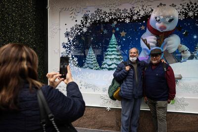 People take picture in front of Macy's Christmas window installation in New York on December 2. AFP