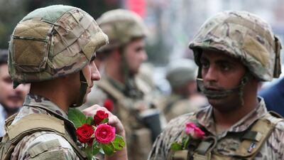 Soldiers wear roses given by demonstrators during an anti-government protest in Nabatiyeh. Reuters