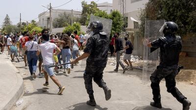 Members of Tunisian security forces charge to disperse anti-government demonstrators during a rally in front of the Parliament in the capital Tunis.