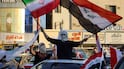A man waves the flags of Iraq and Iran from the sunroof of a car during recent ceasefire celebrations in Baghdad. AFP