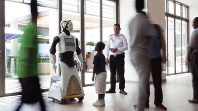 A young boy is mesmerised by Reem the Robot at Yas Mall. Delores Johnson / The National
