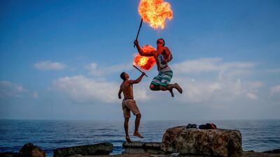 Palestinian firebreathers entertain children on a beach in Gaza City. AFP