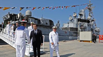 A military band played La Marseillaise and an honour guard met Mr Macron before he boarded and walked through the French frigate Jean Bart. Ludovic Marin / AFP